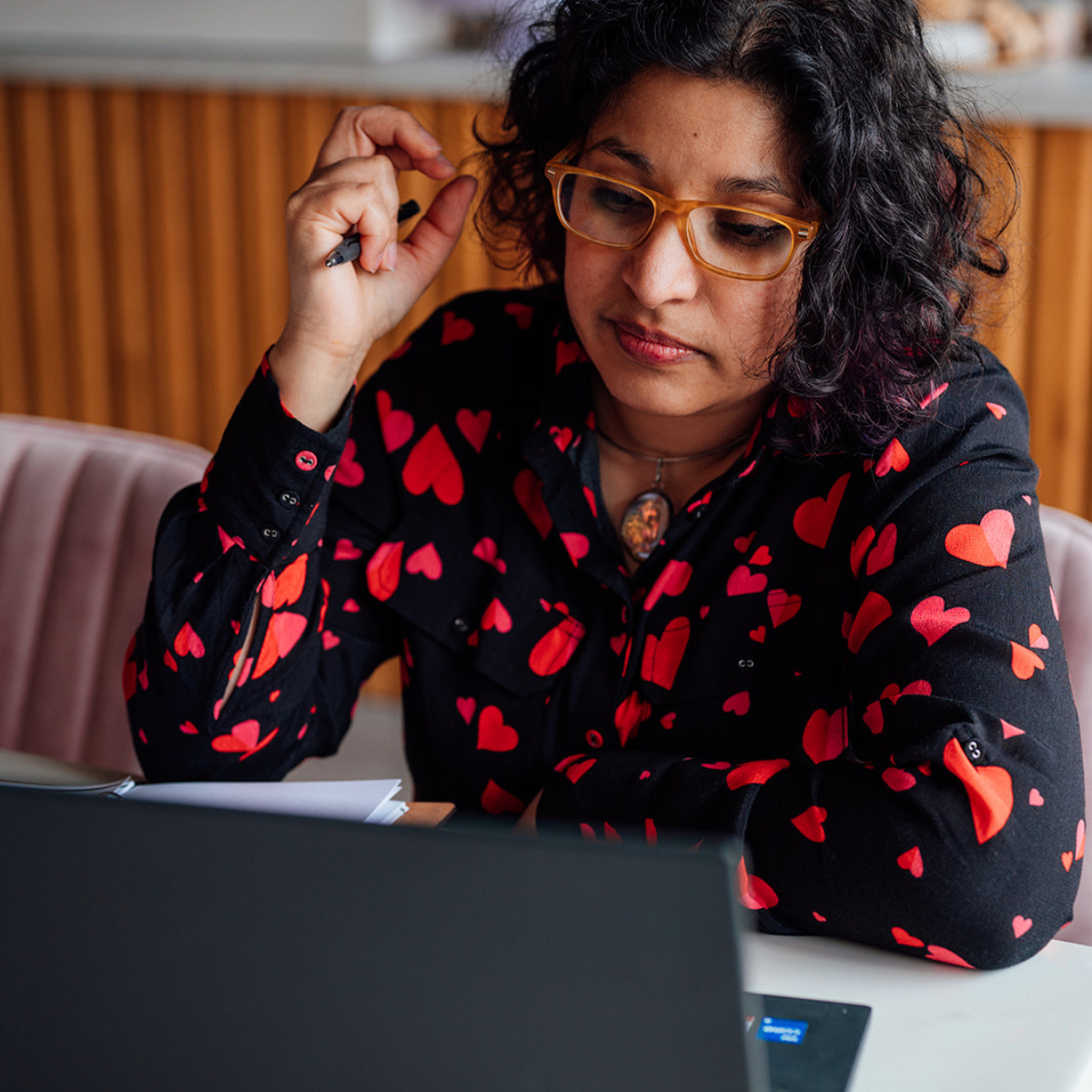 Anuradha listening and working at a laptop
